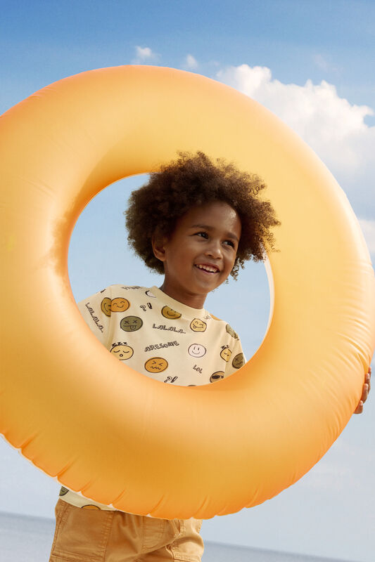 Kind trägt die Minymo Shorts in Orange – perfektes Sommeroutfit für Strand und Alltag.
