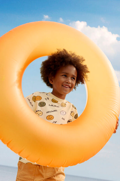 Kind trägt die Minymo Shorts in Orange – perfektes Sommeroutfit für Strand und Alltag.
