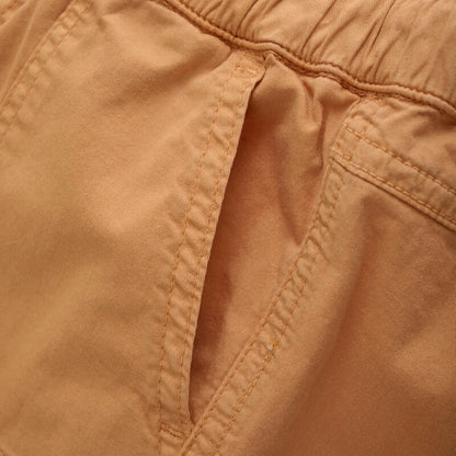 Detailaufnahme der praktischen Taschen und des Bunds der Minymo Shorts in Orange, aus nachhaltigem Material.