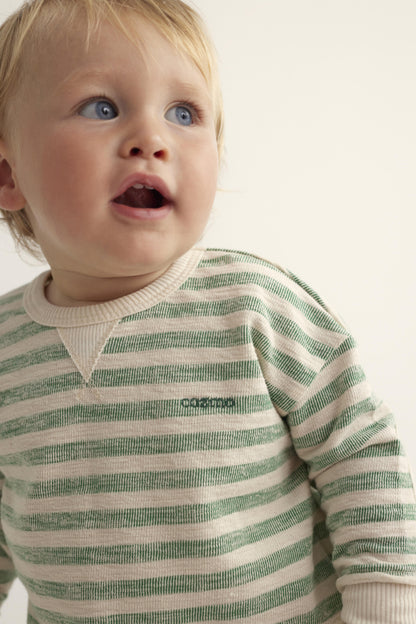 Nahaufnahme eines Kindes im Unisex Baby Sweatshirt mit grünen und cremefarbenen Streifen. Kuscheliger und hautfreundlicher Pullover für Babys und Kleinkinder.