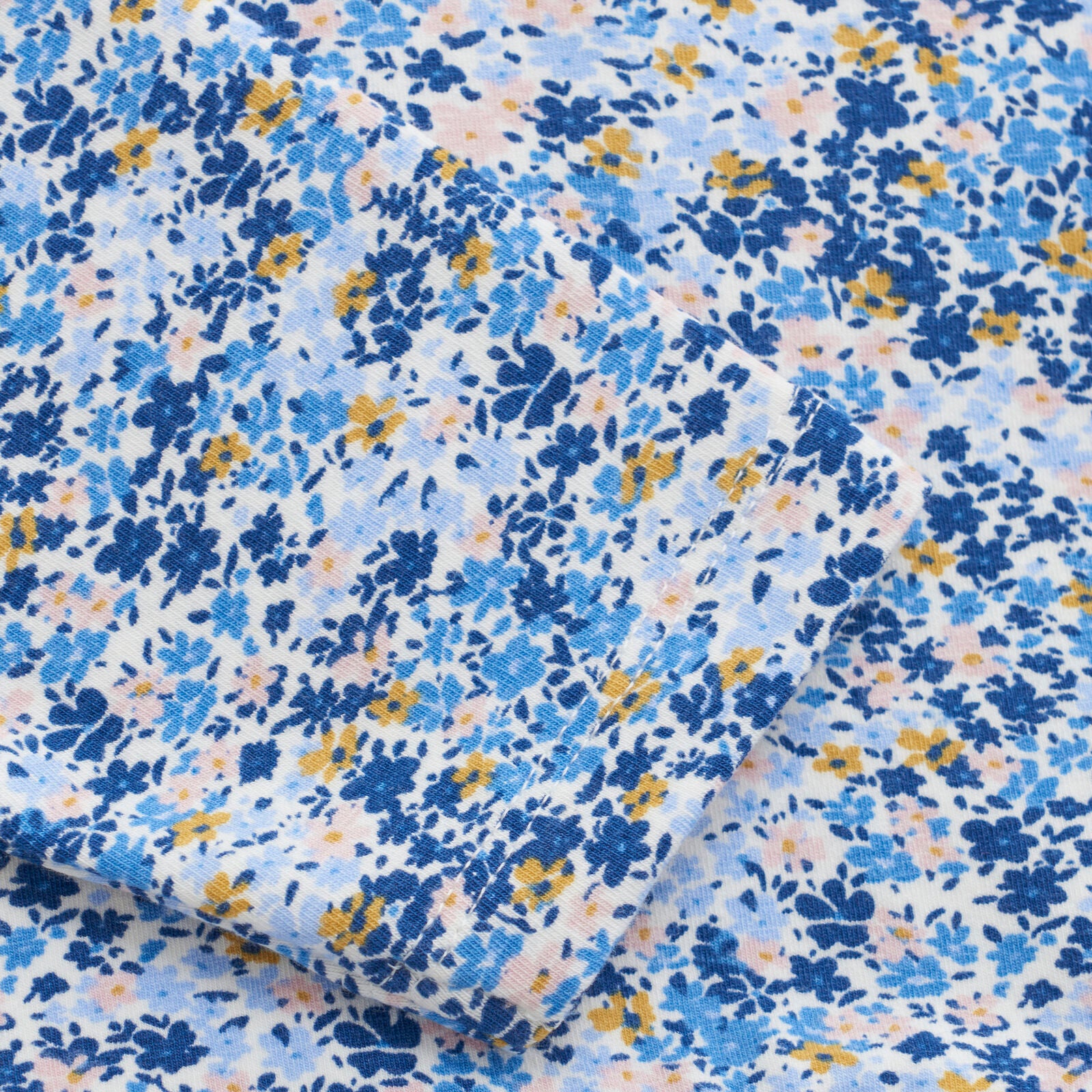 Detailansicht des weichen Minymo Kleids aus Modal und Baumwolle mit floralem Print in Blau.