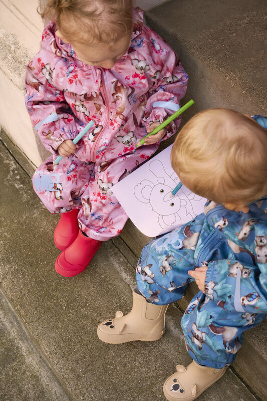 Kinder tragen die beigen „Wellies Short – Koala“ Gummistiefel beim Spielen im Freien, wasserfest und bequem.